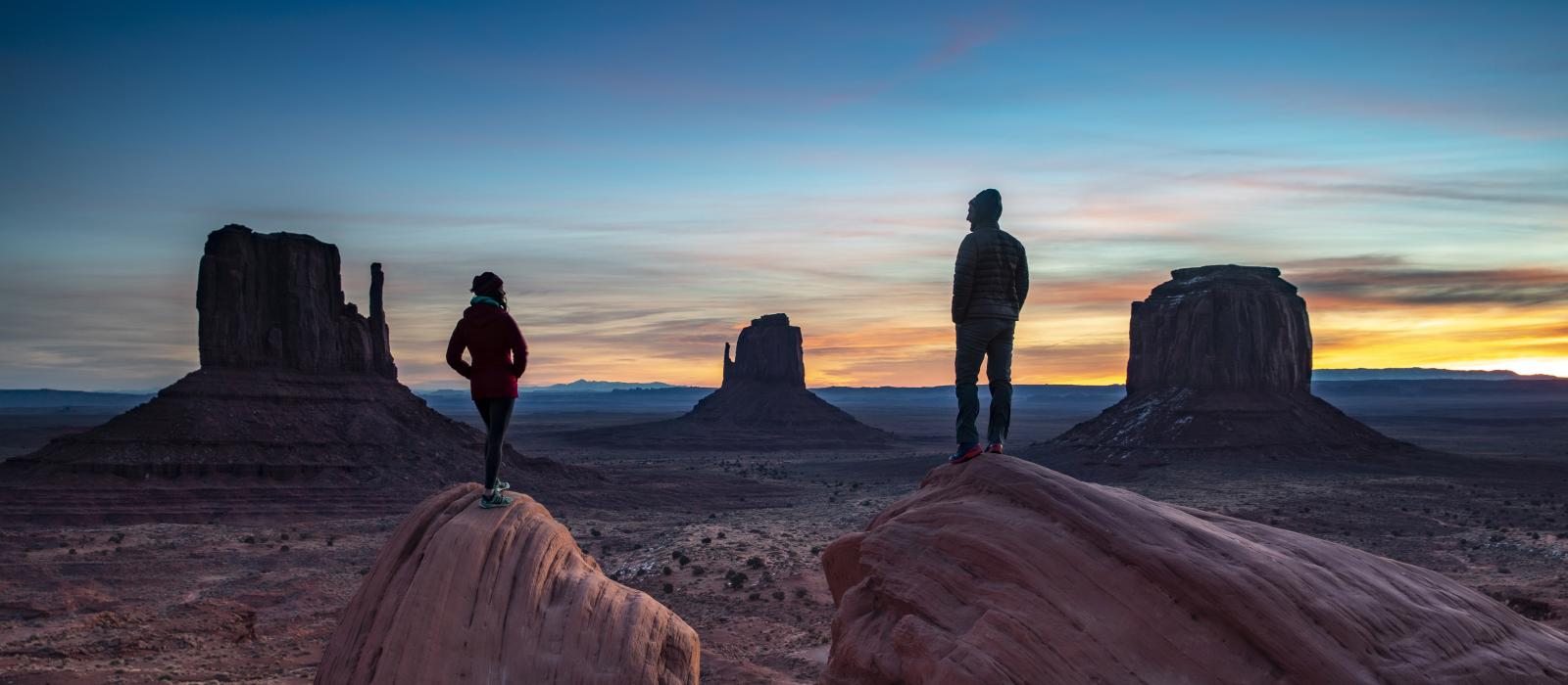 Hikers taking in views of Monument Valley Navajo Tribal Park on the Utah-Arizona border Hikers taking in views of Monument Valley Navajo Tribal Park on the Utah-Arizona border