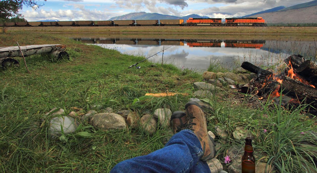 Relajación frente a una fogata mientras pasa el tren en Frog Pond, Montana Relajación frente a una fogata mientras pasa el tren en Frog Pond, Montana