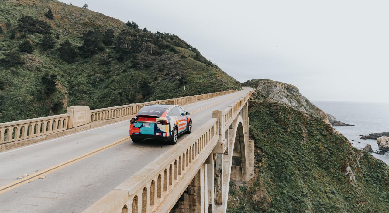 Carro passando pela Bixby Bridge em Big Sur, Califórnia Carro passando pela Bixby Bridge em Big Sur, Califórnia
