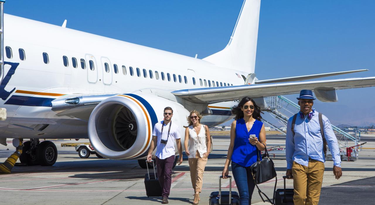 People with luggage disembarking from plane People with luggage disembarking from plane