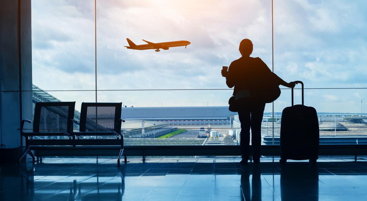 Woman watching plane take off at airport Woman watching plane take off at airport
